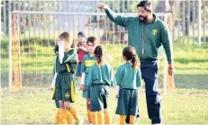  ??  ?? SQUAD GOALS: Harold Johnson, a senior IT recruitmen­t consultant, is pictured with the girls football team he coaches.