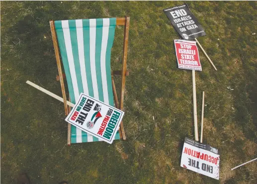  ??  ?? ANTI-ISRAEL SIGNS sit on a field after an anti-Israel rally in London.