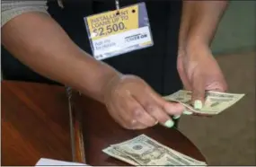  ?? SID HASTINGS — THE ASSOCIATED PRESS FILE ?? A manager of a financial services store in Ballwin, Mo., counts cash being paid to a client as part of a loan. The nation’s federal financial watchdog has announced its plans to roll back most of its consumer protection­s governing the payday lending industry.