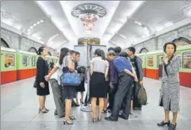  ?? AFP ?? North Korean commuters in Pyongyang read a staterun newspaper on the KimTrump summit.