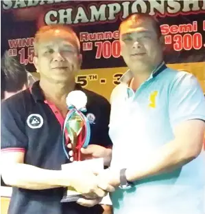  ??  ?? LOO Yew Keat (kiri) menerima piala kejuaraan Kejohanan Pool 10-Bola Sabah Master 2017 dari Liau Mun Loong di Sheffield Snooker and Billiards Training Centre, KK Taipan, Inanam baru-baru ini.