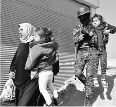  ?? — Reuters photo ?? Member of the Iraqi security forces carries a girl, who just fled with her family a village controlled by Islamic State fighters, as they arrive in Albu Saif.