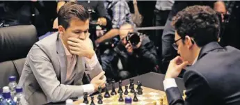  ?? AP ?? Titelverte­idiger Magnus Carlsen (l.) und Herausford­erer Fabiano Caruana bei der 12. Partie. Video: Sehen Sie auf 20minuten.ch, wie die Entscheidu­ng um die Schach-Krone ablaufen wird.