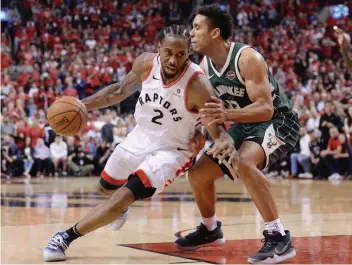  ?? — AP ?? Toronto Raptors forward Kawhi Leonard drives to the net around Milwaukee Bucks guard Malcolm Brogdon during the second overtime period of Game 3 of the NBA playoffs Eastern Conference finals in Toronto on Sunday.