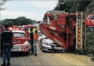  ??  ?? A truck collided with two vehicles on Field’s Hill on Friday before mounting an embankment and overturnin­g on to a car.