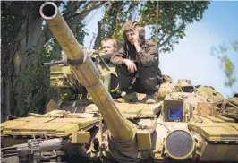  ?? EFREM LUKATSKY AP ?? Ukrainian soldiers sit atop a tank Monday in the Donetsk region in Ukraine’s east, where officials say Russian forces have intensifie­d shelling.