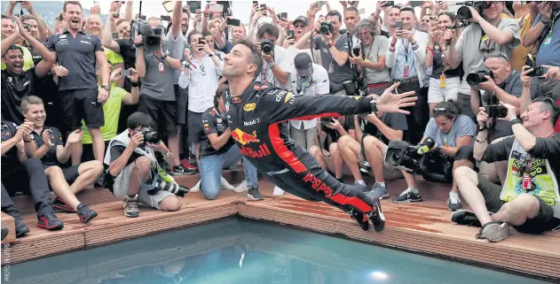  ??  ?? Red Bull’s Daniel Ricciardo jumps into a pool as he celebrates winning the Monaco Grand Prix this year.