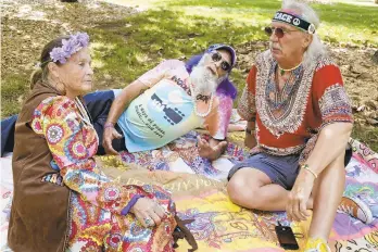  ??  ?? Mary and Aaron Walkover, left, from Florida, talk with a man who calls himself “Run-A-Way Bill”, right, from Virginia, while waiting for the gates to open at a Woodstock 50th anniversar­y event in Bethel, N.Y., on Thursday. Woodstock fans are expected to get back to the garden to mark the 50th anniversar­y of the generation-defining festival. Bethel Woods Center for the Arts is hosting a series of events Thursday through Sunday at the bucolic 1969 concert site, 80 miles (130 kilometers) northwest of New York City.