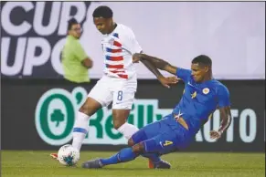  ?? The Associated Press ?? EVADING THE TACKLE: Curacao’s Darryl Lachman, right, tries to steal the ball from United States’ Weston Mckennie during the first half of Sunday’s CONCACAF Gold Cup soccer match in Philadelph­ia.