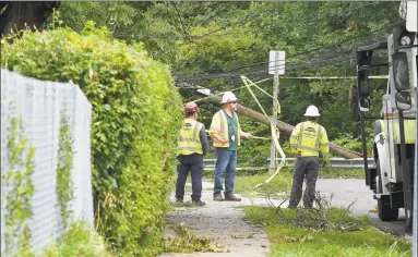  ?? Hearst Connecticu­t Media file photo ?? A crew works at the scene of a downed utility pole and line in Stamford after Tropical Storm Isaias hit. Crews from out of state have teamed up with Eversource crews to fix broken poles and clear fallen trees from lines.