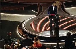  ?? CHRIS PIZZELLO — THE ASSOCIATED PRESS ?? Presenter Chris Rock, right, speaks onstage as Jada Pinkett Smith and Will Smith, bottom left, look on after Smith went onstage and slapped Rock at the Oscars on Sunday at the Dolby Theatre in Los Angeles.