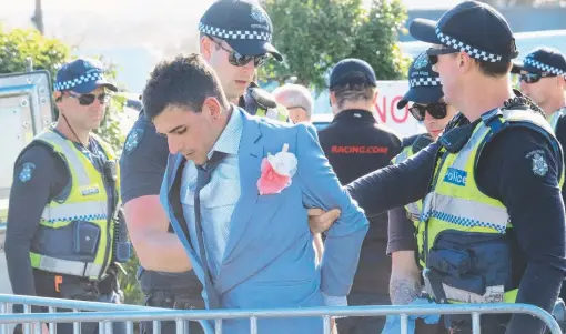  ?? Pictures: MARK WILSON and ALAN BARBER ?? LEFT: Police speaking to racegoers late in the day. BELOW: Former Geelong Mayor Darryn Lyons and his partner Elissa Friday had the crowds looking to the sky with his election advertisin­g.