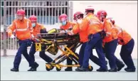  ?? PROVIDED TO CHINA DAILY ?? Rescuers rush firefighte­r Yau Siu-ming, who fell off a slope below a cliff while searching for two lost hikers on Ma On Shan, to hospital on Wednesday. Yau later died in Prince of Wales Hospital.