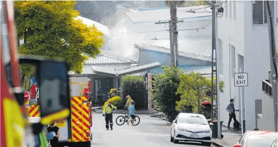  ?? Photo / Dean Purcell ?? Debris from the fire spread into surroundin­g streets, but public health officials say the risk to the public is low.