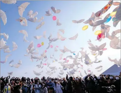  ?? KAZUHIRO NOGI / AFP ?? Doveshaped balloons are released into the sky in a ceremony to mourn earthquake and tsunami victims in Natori, Miyagi prefecture, Japan, on March 11, the 10th anniversar­y of a magnitude 9 earthquake that triggered a tsunami and nuclear disaster killing over 18,000 people in 2011.