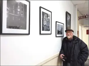  ??  ?? Russ Olivo photo Woonsocket photograph­er Ed Hanson, 75, a resident at Hanora Lippitt Manor, is pictured with a new exhibit of his works at Woonsocket City Hall this week.