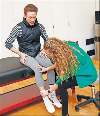  ?? [NATE BILLINGS/ THE OKLAHOMAN] ?? Dr. Megan Meier, a Mercy family medicine and sports medicine physician, examines soloist Walker Martin at the Oklahoma City Ballet's practice facility, 6800 N Classen.
