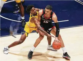  ?? Kathy Batten / Associated Press ?? Texas Tech guard Kevin McCullar, front, is defended by West Virginia guard Kedrian Johnson during the first half of a game between ranked Big 12 teams.