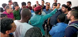  ??  ?? A police officer pacifies tenants of the Ajman One building as they arrived to check their apartments to retrieve their personal documents. The fire that struck the building has affected 300 residents.