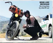  ??  ?? BEND LIKE BECKHAM He crouches by sheriff car