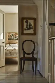  ??  ?? BELOW Tina’s formula of using a single painting to create a focal point is repeated throughout the house. Through the open door into the bedroom, a decorative work hangs above an antique iron bedstead that has been dressed with crisp white linen