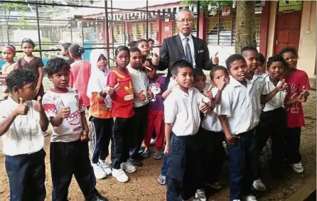 ??  ?? Jalaludin (middle) and the pupils of SK Orang Asli Sungai Berua giving the thumbs up after he performed the groundbrea­king ceremony of the new school block.