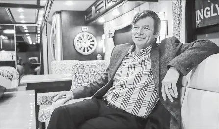  ?? JEFF MCINTOSH THE CANADIAN PRESS ?? Bucars RV Centre general manager Jeff Redmond relaxes in one of the company's recreation­al vehicles worth more than $600,000 in Balzac, Alta. The best prices are usually at the start of the off-season, when more used units are on the market and dealers may be willing to bargain.