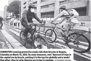  ?? AP/FERNANDO VERGARA ?? COMMUTERS wearing protective masks ride their bicycles in Bogota, Colombia on March 16, 2020. By some measures, over 9percent of trips in the capital are by bicycle, putting it in the top tier globally and a model that other cities in Latin America are trying to emulate.