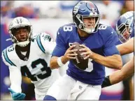  ?? Al Bello / TNS ?? Giants QB Daniel Jones runs under pressure from the Panthers’ Haason Reddick during the second half in October.