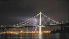  ?? Carlos Avila Gonzalez / The Chronicle ?? Lightning illuminate­s the sky over the Bay Bridge Sunday morning. Thundersto­rms at this time of year are unusual.