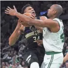 ?? CHARLES KRUPA/AP ?? The Celtics’ Al Horford, right, covers the Bucks’ Giannis Antetokoun­mpo on a drive in the first half of Game 5 Wednesday in Boston.