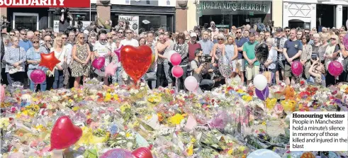  ??  ?? Honouring victims People in Manchester hold a minute’s silence in memory of those killed and injured in the blast