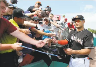  ?? David Santiago / Associated Press 2016 ?? Miami right fielder Giancarlo Stanton signs autographs during a spring training game against Washington in 2016. Offseason player movement virtually has ceased as teams wait to see to which team Stanton, who hit 59 home runs last season, will be traded.