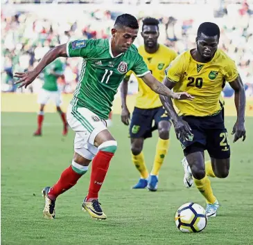  ??  ?? Out of my way:
Mexico’s Elias Hernandez (left) vying for the ball with Jamaica’s Kemar Lawrence in the Concacaf Gold Cup semifinals in Pasadena, California, on Sunday. — AP