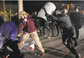  ?? Nathan Howard / Associated Press ?? A police officer shoves a protester Saturday in Portland, Ore., where Black Lives Matter demonstrat­ions have gone on every night for weeks.