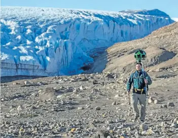  ?? THE CANADIAN PRESS ?? A Parks Canada staff member hikes near Air Force Glacier with the Google trekker in Quttinirpa­aq National Park in Nunavut in July 2016.