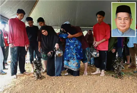  ?? — Bernama ?? Dearly missed: Rohaizan pouring rose water over the grave of her husband Mohd Shohaimi (inset) during the funeral at the Kampung Sri Fajar Muslim Cemetery in Gambang.