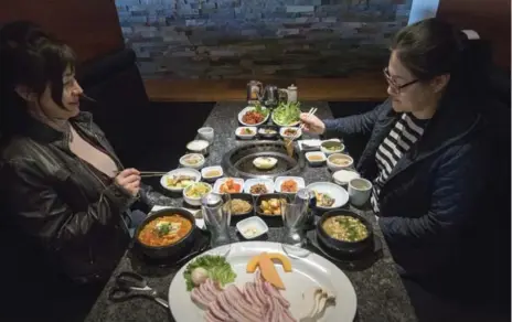  ?? J.P. MOCZULSKI PHOTOS FOR THE TORONTO STAR ?? Grilling your own pork belly and vegetables is one way of enjoying a meal at Hansik Korea. Or you can ask the waiter to man the table-top barbecue.