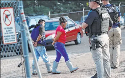  ?? Rogelio V. Solis The Associated Press ?? Two people are taken into custody at a Koch Foods Inc. plant in Morton, Miss., on Wednesday. U.S. immigratio­n officials raided several Mississipp­i food processing plants on Wednesday in the largest workplace sting in at least a decade.