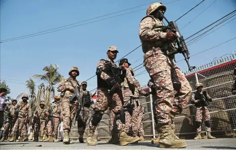  ??  ?? Securing the premises: Troops taking up positions in the compound of the Chinese Consulate in Karachi. — AP