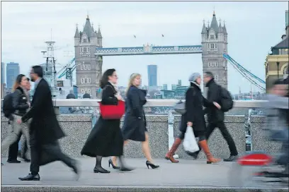  ?? [TIM IRELAND/THE ASSOCIATED PRESS] ?? A woman walks in high heels across London Bridge on Monday as Parliament debates company dress codes that ban women from wearing flat shoes.