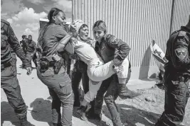  ?? MARCUS YAM Los Angeles Times ?? Israeli troops struggle to remove a protester from a sit-in that was intended to block shipments of aid into the Gaza Strip last week.