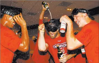  ?? Amber Searls ?? USA Today Las Vegas native Bryce Harper, center, celebrates with his Nationals teammates Sunday after Washington beat the Phillies 3-2 and clinched the National League East championsh­ip.