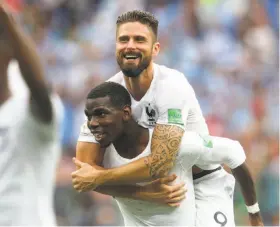  ?? Alexander Hassenstei­n / Getty Images ?? France’s Paul Pogba and Olivier Giroud (top) celebrate after beating Uruguay 2-0 in their World Cup quarterfin­al match Friday in Nizhny Novgorod, Russia.