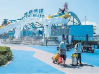  ?? ANTHONY WALLACE AFP/GETTY IMAGES ?? Workers walk through the grounds of a closed theme park, Ocean Park, in Hong Kong on Monday.