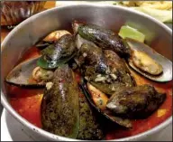  ?? Arkansas Democrat-Gazette/ERIC E. HARRISON ?? Lulu Sauce coats a pound of enormous Pacific mussels at Lulu’s Crab Boil in the Heights.