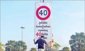  ?? TNN ?? A worker installs a 40km/h speed limit sign in Phnom Penh recently.