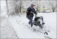  ?? PETER PEREIRA — THE STANDARD-TIMES VIA AP ?? Postman Josh Ashley fights the driving snow and cold weather, as he make his way up Main Street in Fairhaven, Mass., using a cart to deliver mail on Friday.