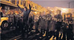  ?? JESSICA GRIFFIN THE PHILADELPH­IA INQUIRER VIA THE ASSOCIATED PRESS ?? Sharif Proctor lifts his hands in front of a police line during a protest in in Philadelph­ia Monday.