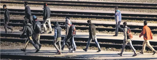  ?? Pictures: PHILIPPE HUGUEN/ AFP PASCAL ROSSIGNOL/ REUTERS ?? Migrants flood on to the tracks at the Eurotunnel terminal near Calais on Tuesday night. Authoritie­s said around 15,000 tried to force their way on to trains